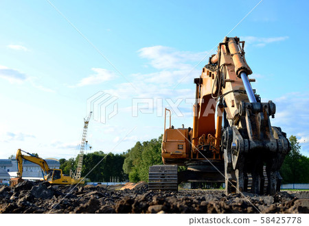 Excavator with hydraulic shears breaks asphalt on a construction site Excavator with hydraulic shears breaks asphalt on a construction site 58425778