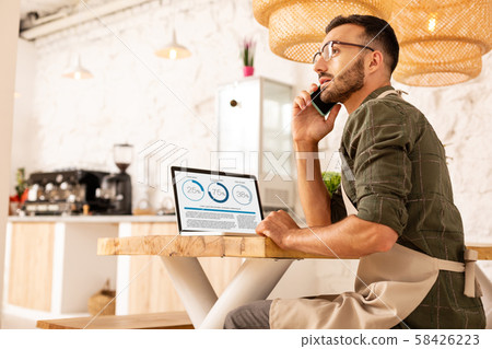 Businessman calling investor while sitting in coffee shop 58426223