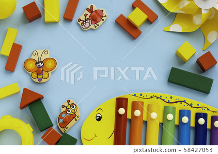 Top view on children's educational and music games, frame from multicolored kids toys on light blue 58427053
