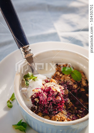 baked oat-blueberry crumble with mint in a white baked oat-blueberry crumble with mint in a white 58430701