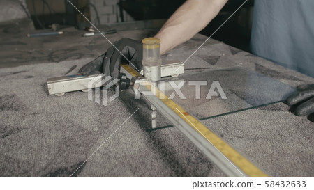 Glass cutting and processing for fireplace doors. Circular glass cutter. Worker cut glass with glass 58432633