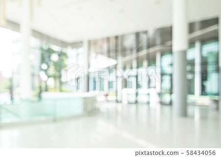 Blur background interior view looking out toward to empty office lobby and entrance doors and glass curtain wall Blur background interior view looking out toward to empty office lobby and entrance doors and glass curtain wall 58434056