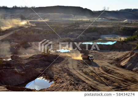 Dump truck transports sand and other minerals in the mining quarry. 58434274