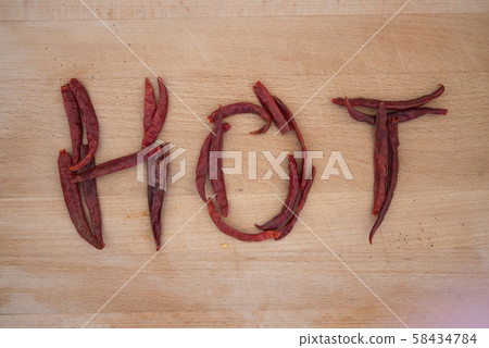 Chilli or chili align into word art HOT on wooden board 58434784