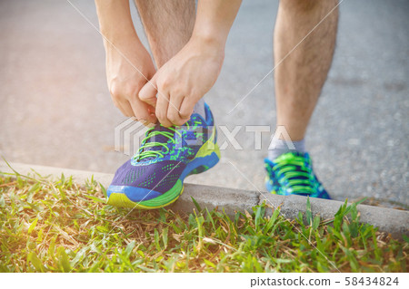 Man runner tying running shoes before run for Man runner tying running shoes before run for 58434824