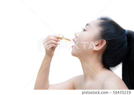 Woman holding a dropper sublingual Cannabis oil at white background Woman holding a dropper sublingual Cannabis oil at white background 58435219