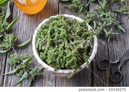 Nettle seeds in a bowl with a jar of honey 58436275