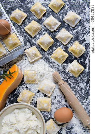 traditional raw ravioli with pumpkin on a wooden table with flour, handmade, cooking process traditional raw ravioli with pumpkin on a wooden table with flour, handmade, cooking process 58437055