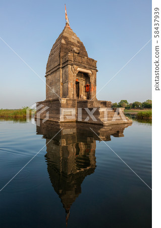 Small Hindu temple in the middle of the holy Narmada River, Maheshwar, Madhya Pradesh state, India 58437939