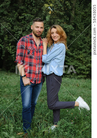 Full height outdoors portrait of bearded hipster boyfriend in red shirt and blond Girlfriend wearing Full height outdoors portrait of bearded hipster boyfriend in red shirt and blond Girlfriend wearing 58438055