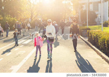 Adult young beautiful mother with cute adorable blond child girl having fun walking together at city Adult young beautiful mother with cute adorable blond child girl having fun walking together at city 58438800
