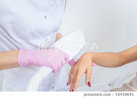 laser hair removal. Closeup of beautician hair removal hands of a young woman. Procedure Of Cosmetic laser hair removal. Closeup of beautician hair removal hands of a young woman. Procedure Of Cosmetic 58439645