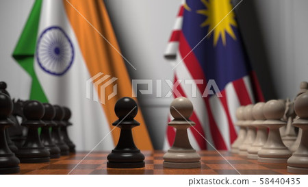 Flags of India and Malaysia behind pawns on the chessboard. Chess game or political rivalry related 58440435