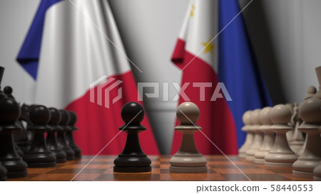 Flags of France and Philippines behind pawns on the chessboard. Chess game or political rivalry Flags of France and Philippines behind pawns on the chessboard. Chess game or political rivalry 58440553