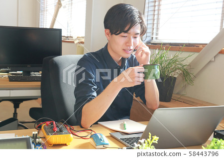 Engineer 1 holding a mug while calling 58443796