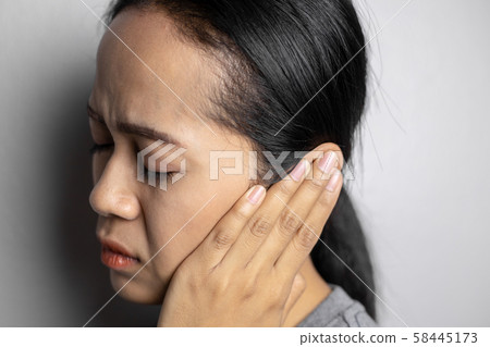 Young woman is suffering of earache. Young woman is suffering of earache. 58445173
