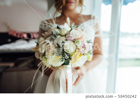 Beautiful bride is holding a wedding colorful bouquet. Beautiful bride is holding a wedding colorful bouquet. 58450242