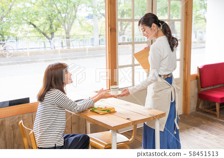 Female clerk at cafe serving coffee 58451513