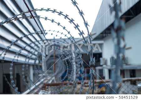 Barbed wire fences installed on the wall to protect the area from thieves or prevent prisoners escape. 58451529