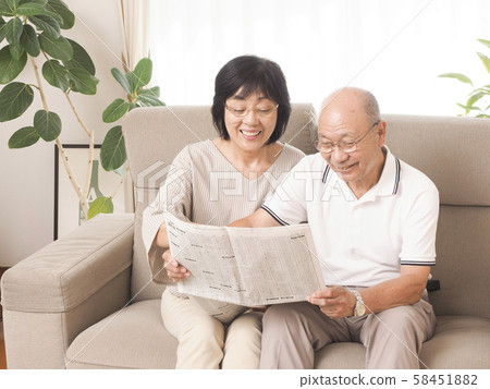 Senior laughing at newspaper stock column 58451882