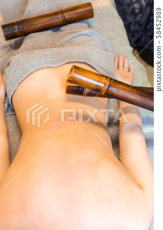 Body massage with bamboo sticks. Oriental method of back massage with bamboo. 58452989