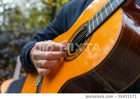 Two friends playing guitars in autumn park 58455171