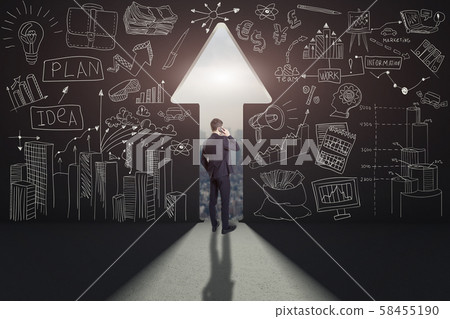 Rear view of a businessman against black wall with a path in it 58455190