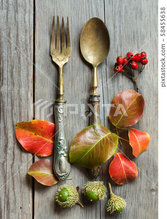 Vintage fork and knife with autumn leaves on wood 58455638