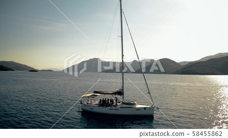 Aerial shot of unknown people relaxing on a sailing yacht at the Ionian Sea, Greece Aerial shot of unknown people relaxing on a sailing yacht at the Ionian Sea, Greece 58455862
