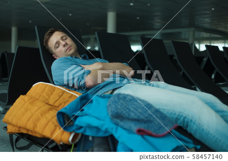 Mature man in airport sleeping on a bench Mature man in airport sleeping on a bench 58457140