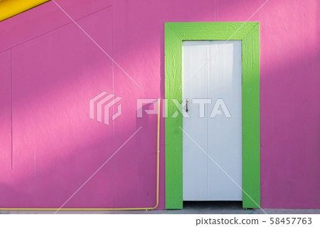Green wooden doors and pink wall in sunlight 58457763