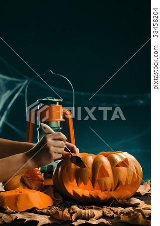 woman prepares for halloween and carving a pumpkin woman prepares for halloween and carving a pumpkin 58458204