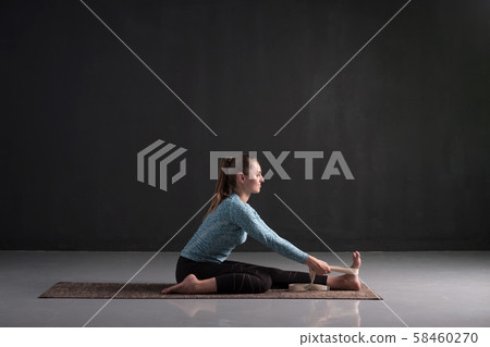 practicing yoga, doing paschimottanasana exercise, Seated forward bend pose practicing yoga, doing paschimottanasana exercise, Seated forward bend pose 58460270
