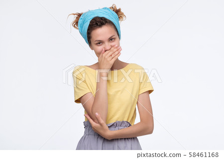 Woman with dreadlocks bursting into laughing covering mouth with hands 58461168