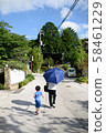 Woman with parasol and child's back 58461229