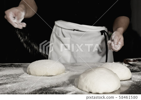 Chef prepares the dough with flour to make a pizza. Chef prepares the dough with flour to make a pizza. 58461580