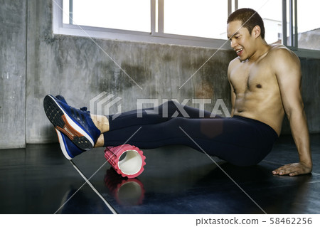 Athletic Asian man using a foam roller after a 58462256