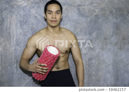 Athletic Asian man using a foam roller after a Athletic Asian man using a foam roller after a 58462257