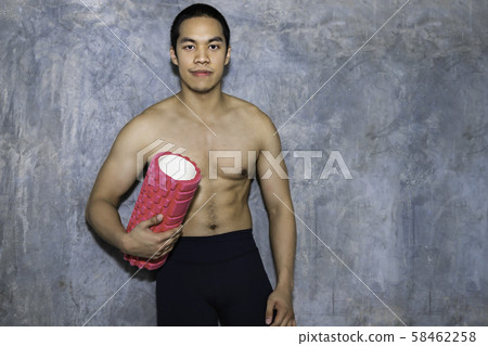 Athletic Asian man using a foam roller after a Athletic Asian man using a foam roller after a 58462258