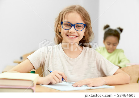 Smart girl posing while doing task during lesson 58464605