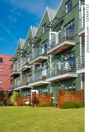Residential apartment building with green lawn in front Residential apartment building with green lawn in front 58464733