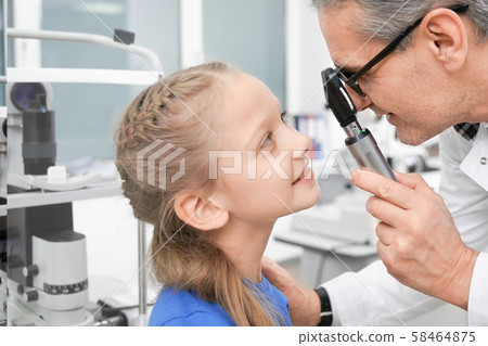 Side view of pretty girl testing vision in optical store 58464875