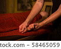 Masseur doing hand massage for female client 58465059
