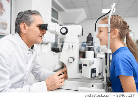 Elder doctor working and testing vision with slit lamp Elder doctor working and testing vision with slit lamp 58465127