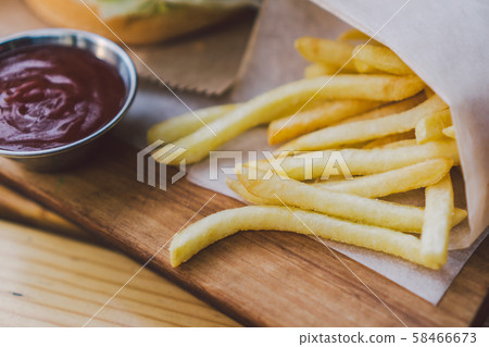 Fresh tasty burger and french fries on wooden table. french fries and bbq sauce on wood plate Fresh tasty burger and french fries on wooden table. french fries and bbq sauce on wood plate 58466673