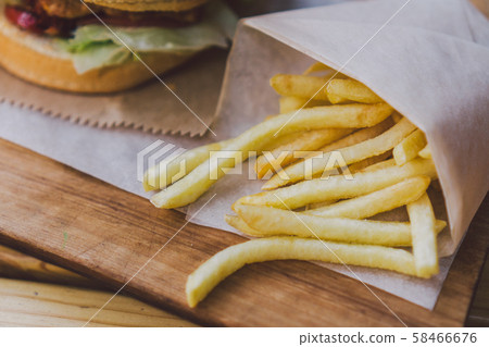 Fresh tasty burger and french fries on wooden table. french fries and bbq sauce on wood plate Fresh tasty burger and french fries on wooden table. french fries and bbq sauce on wood plate 58466676