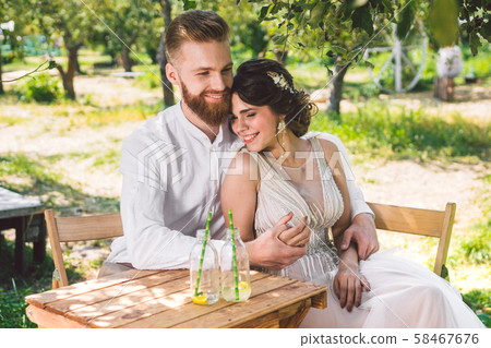 Attractive couple newlyweds, happy and joyful moment. bride and groom sit at table set for two in 58467676