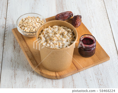 Oatmeal porridge with dates in a cardboard cup. Oatmeal porridge with dates in a cardboard cup. 58468224