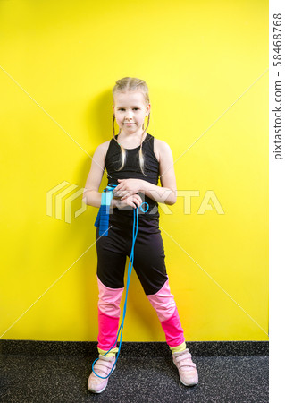 Theme sport and health. Beautiful caucasian child girl with pigtails posing yellow background with 58468768