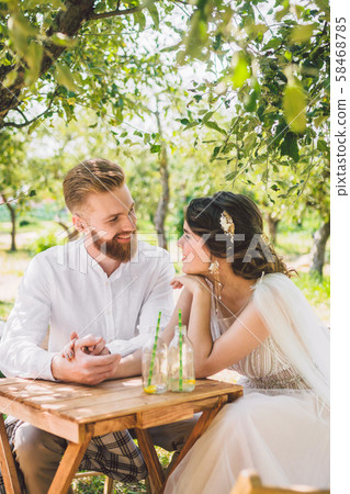 Attractive couple newlyweds, happy and joyful moment. bride and groom sit at table set for two in Attractive couple newlyweds, happy and joyful moment. bride and groom sit at table set for two in 58468785